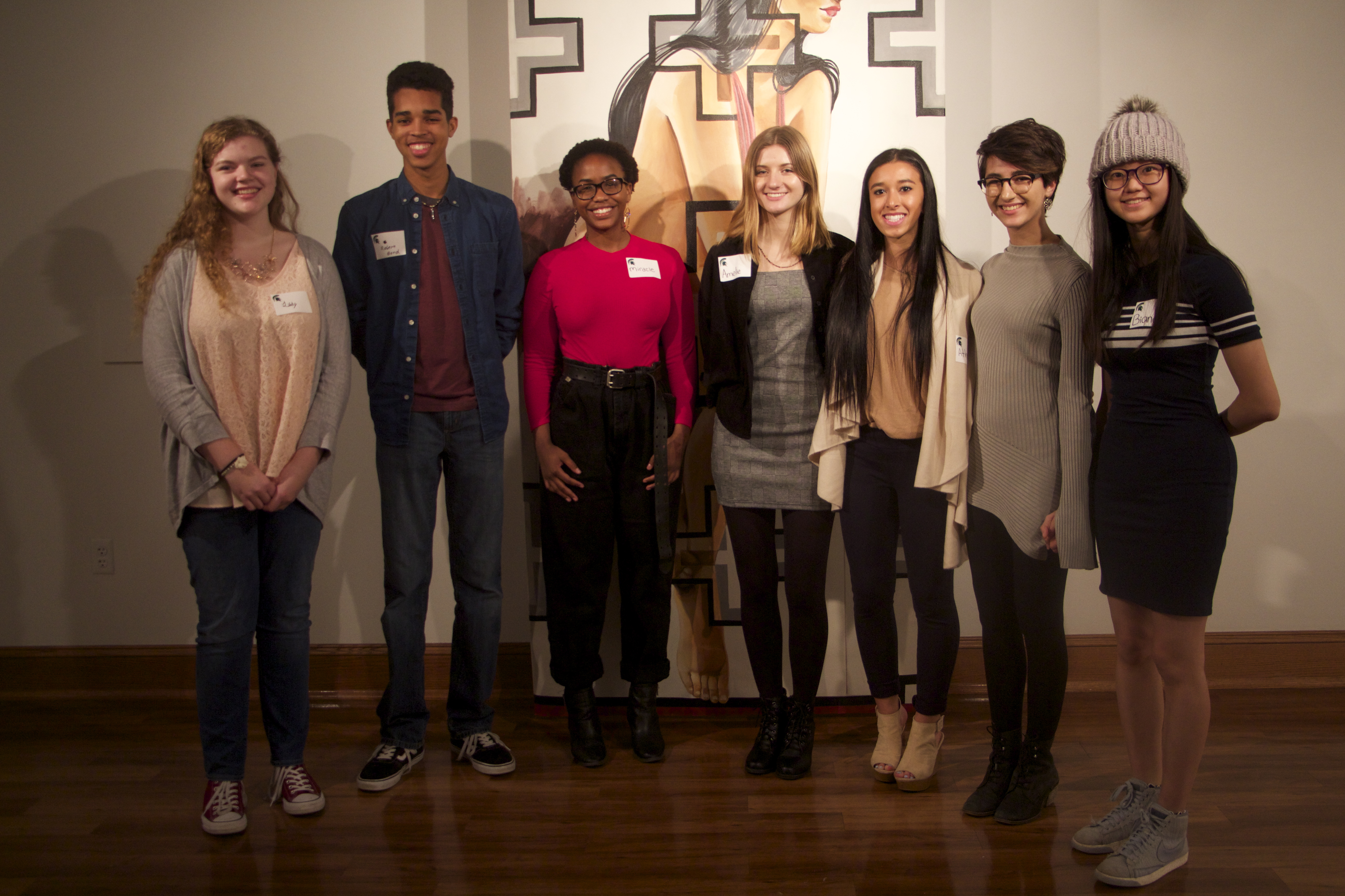 Seven young adults standing and facing the camera for a group photo