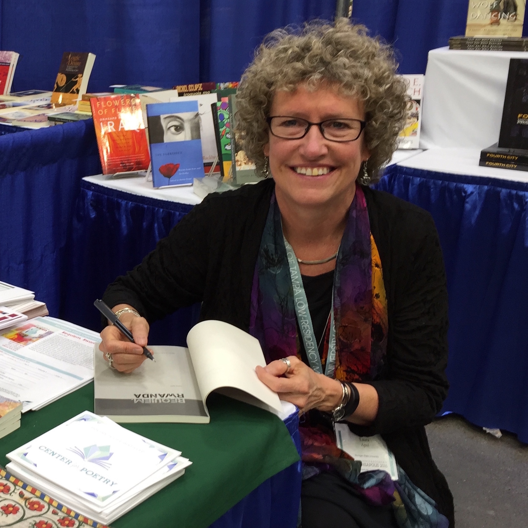 Woman signing books and smiling at viewer