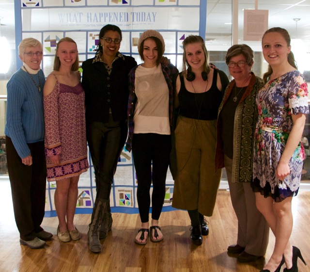 Seven women stand facing the camera for a posed group photo